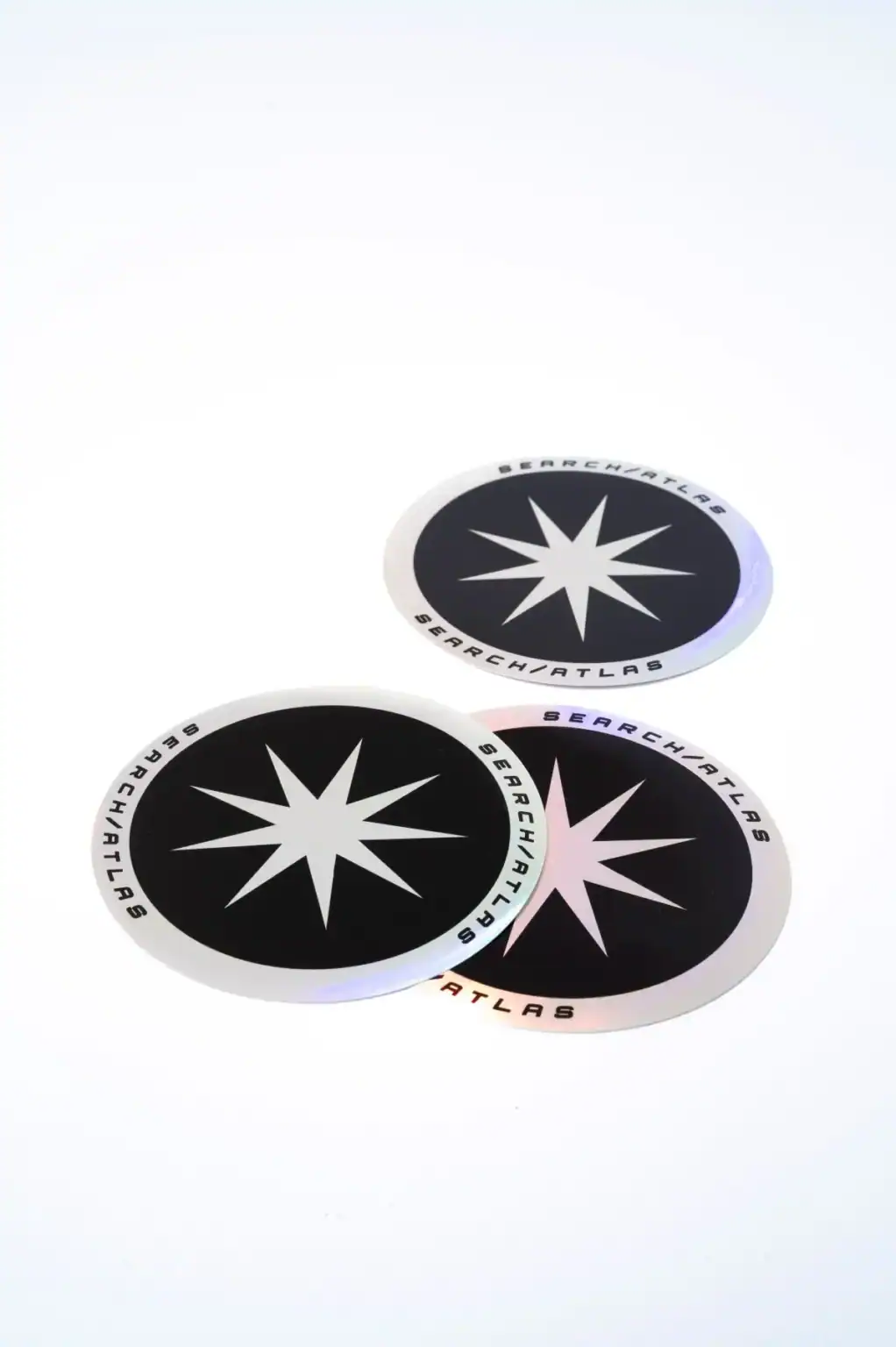 Search Atlas logo stickers, round black and white designs with starburst icon and "Search Atlas" text, perfect for branding, laptops, and merchandise.