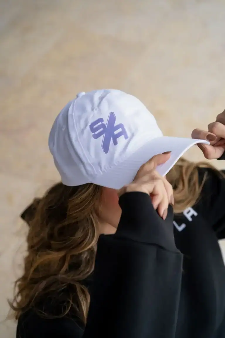 White baseball cap with purple logo, casual streetwear accessories, stylish headwear for women and men, trendy sportswear cap, fashionable headgear for outdoor activities, Search Atlas Store merchandise.