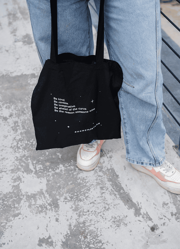 Black tote bag with inspiring quotes and star design, perfect for daily use and shopping.