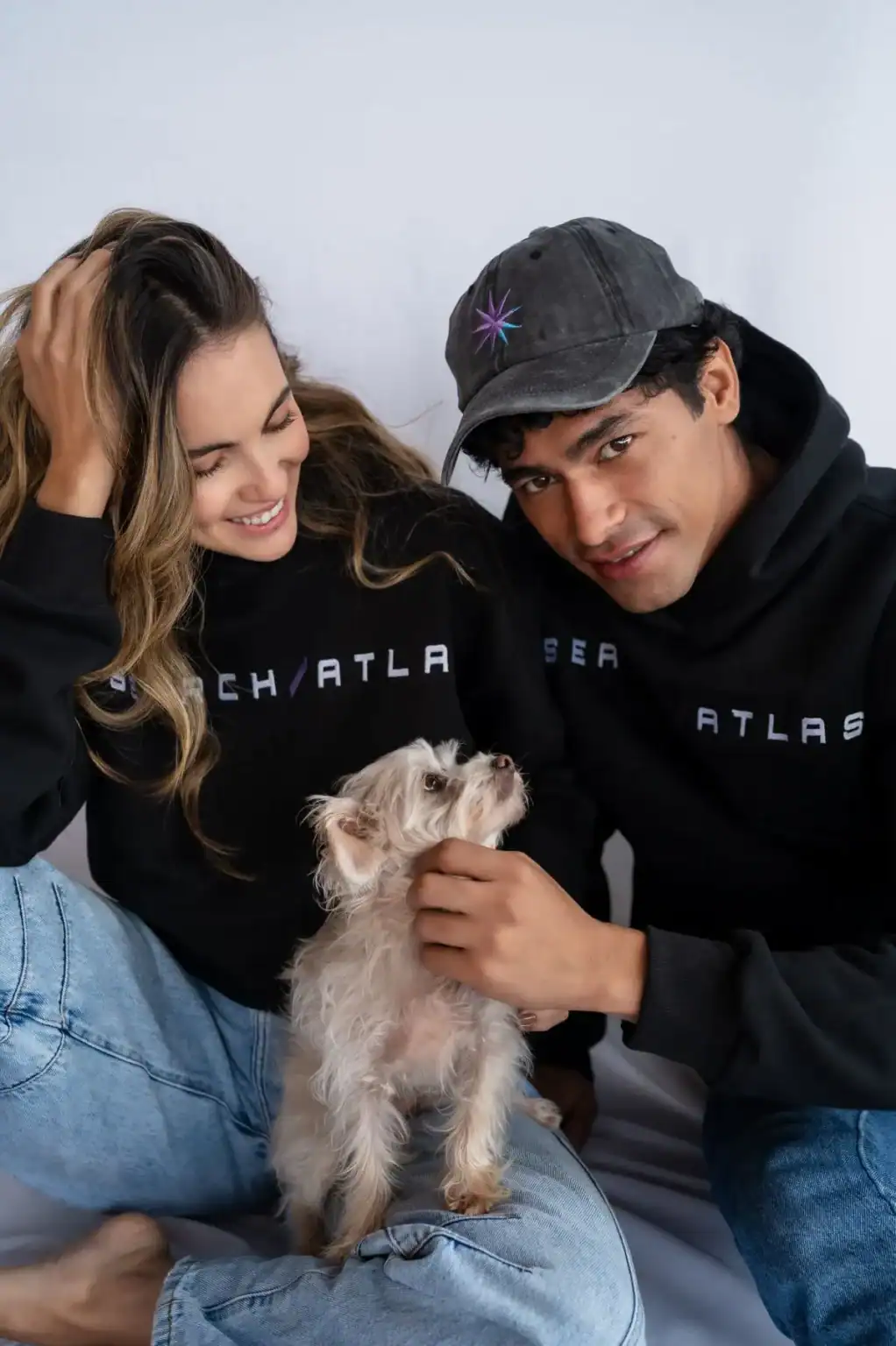Cute couple with a small dog wearing matching Search Atlas Store hoodies, showcasing trendy streetwear fashion and pet accessories. Perfect for fashion, lifestyle, and pet lovers.