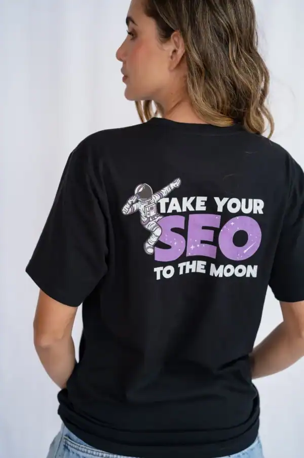 Bold black T-shirt with space-themed graphic and motivational message about SEO and digital marketing, featuring an astronaut and the slogan "Take Your SEO to the Moon.".