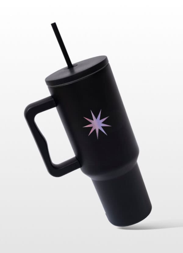 Stylish black reusable travel mug with lid and straw, featuring a purple starburst design, perfect for coffee or beverages on the go.