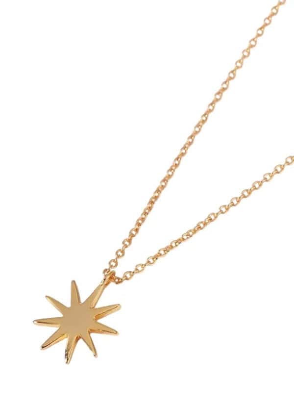 Gold star pendant necklace on delicate chain, perfect for stylish layered jewelry. Elegant accessory for everyday wear or special occasions.