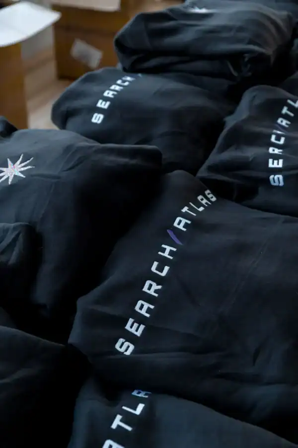 Search Atlas branded black hoodies with reflective logo, apparel for gaming and tech enthusiasts, comfortable, high-quality merchandise, perfect for fans of Search Atlas community.